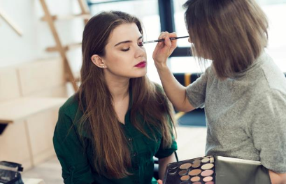 Makeup artist appling makeup to woman Makeup artist appling makeup to woman